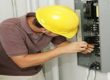 man in hard hat working on an electrical panel