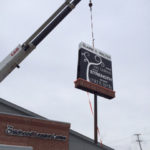 crane installing a sign above a building