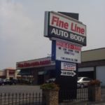 Fine Line Auto Body building with tall stand alone sign out front in foreground