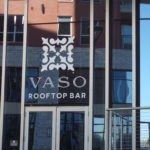 Vaso Rooftop Bar logo on glass mirrored window above restaurant door