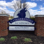Cornerstone Academy sign with brick posts and wolf logo