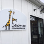 Delaware Pediatric Dentistry sign on outside of building next to door