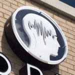 closeup of sign with head logo